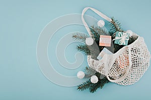 Christmas composition. New Year or Christmas flat lay, top view with trend eco friendly modern cotton net bag with fir branches,
