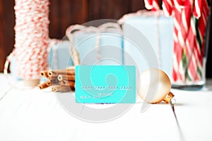 Christmas composition New Year selling discount concept blue credit card  with xmas gifts sweets toys balls rope cinnamon on white