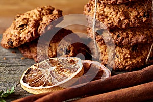 Christmas composition with oatmeal, chocolate biscuits, and spices, on wooden background, close-up, selective focus.