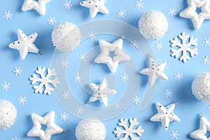 Christmas composition. Pattern made of white snowflakes, balls, stars, confetti on blue background. Flat lay, top view