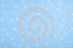Christmas composition. Pattern made of white snowflakes on blue background. Flat lay, top view
