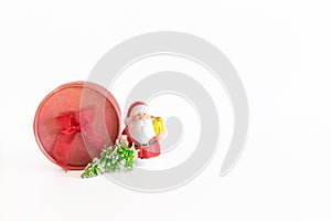 Christmas composition with red gift box, santa toy, fir branch, holiday decoration on white background with copy space
