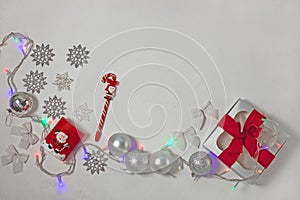 Christmas composition of red and silver decorations, gift box with ribbon bow, flatlay