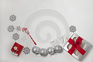 Christmas composition of red and silver decorations, gift box with ribbon bow, flatlay