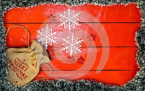 Christmas composition on red wooden board with Christmas garland and decorations. Creative composition with border and copy space