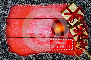 Christmas composition on red wooden board with Christmas garland and decorations. Creative composition with border and copy space