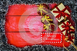 Christmas composition on red wooden board with Christmas garland and decorations. Creative composition with border and copy space