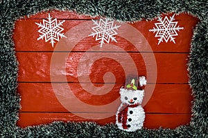 Christmas composition on red wooden board with Christmas garland and decorations. Creative composition with border and copy space