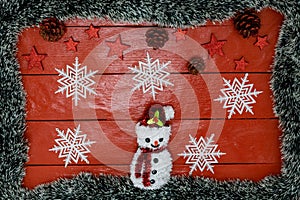 Christmas composition on red wooden board with Christmas garland and decorations. Creative composition with border and copy space