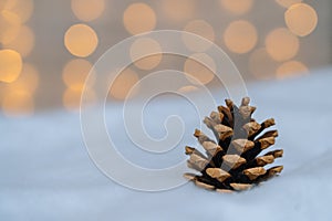 Christmas composition with red wooden Santa Claus sleigh, fir cone and Xmas tree balls over blurred light background