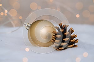 Christmas composition with red wooden Santa Claus sleigh, fir cone and Xmas tree balls over blurred light background