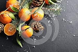 Christmas composition with ripe tangerines and space for text on black background
