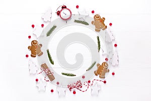 Christmas composition. Round frame made of decorations, fir tree branches, gingerbread man cookies on white background. Winter ho