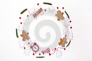 Christmas composition. Round frame made of decorations, fir tree branches, gingerbread man cookies on white background. Winter ho