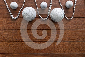 Christmas composition with silver chain and balls on a wooden background