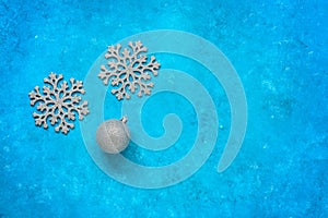 Christmas composition. Silvery snowflakes and Christmas ball on a blue grunge background. Top view, flat lay