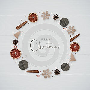 Christmas composition with snowflakes, cinnamon, orange slices, pine cones and decorative paper balls isolated on wooden backgroun