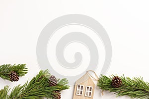 Christmas composition. Spruce branches with small wooden house, on a white background