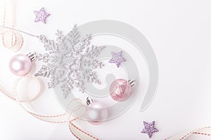 Christmas composition. Spruce branches, xmas tree, xmas pink decor holiday ball with ribbon on white background.