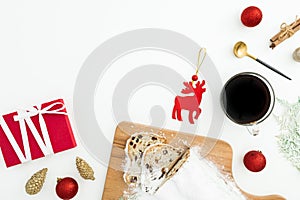 Christmas composition with stollen cake and coffee, tree toys and gift box on white. Flat lay, top view. Cpoy space
