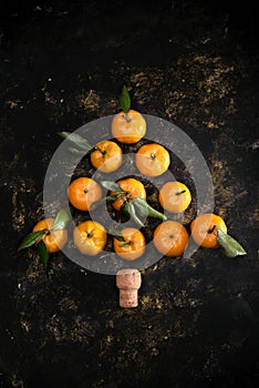 Christmas composition with tangerines on black background, flat lay