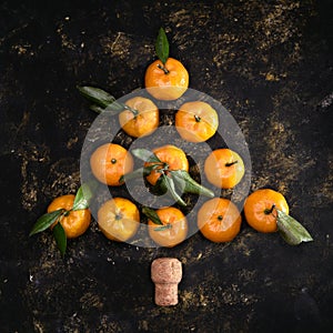 Christmas composition with tangerines on black background, flat lay