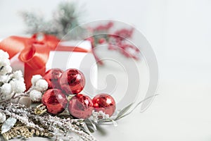 Christmas composition. Tree branches, red balls decorations on snowflakes white background.