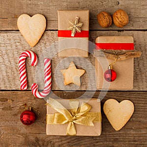 Christmas composition of various gift boxes wrapped in craft paper and decorated with satin red gold ribbons and holiday sweetness