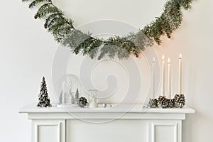 Christmas composition on the white chimney at the living room interior with beautiful decoration.