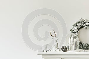Christmas composition on the white chimney at the living room interior with beautiful decoration. Christmas tree and wreath.