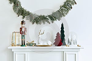 Christmas composition on the white chimney at the living room interior with beautiful decoration. Christmas tree and wreath.