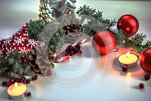 Christmas composition on wooden background red balls, gifts, and green Christmas tree branch with cones,burning candle