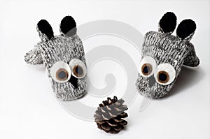 Christmas composition. Woolen knitted mittens in dogs with pine cone. isolated white.