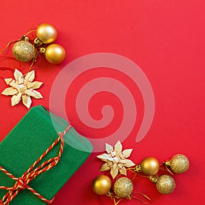 Christmas composition. Wrapped gift, golden toys on red background. new year concept. Greeting card, xmas celebration 2020. Flat