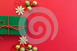 Christmas composition. Wrapped gift, golden toys on red background. new year concept. Greeting card, xmas celebration 2020. Flat