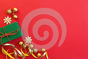 Christmas composition. Wrapped gift, golden toys on red background. new year concept. Greeting card, xmas celebration 2020. Flat