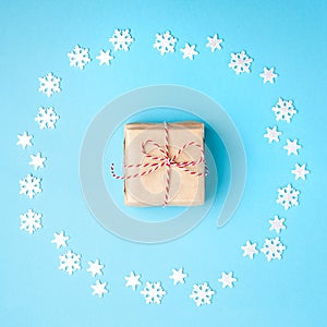 Christmas composition. Wreath made of snowflakes with gift in the center on pastel blue background. Christmas, winter, new year