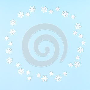 Christmas composition. Wreath made of snowflakes on pastel blue background. Flat lay, top view, copy space