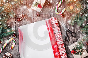 Christmas composition with xmas wrapping, Fir branches, gifts, pine cones, red decorations on wooden background.