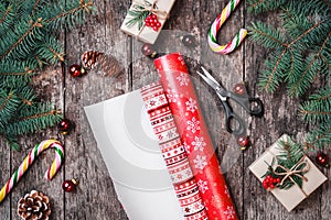 Christmas composition with xmas wrapping, Fir branches, gifts, pine cones, red decorations on wooden background