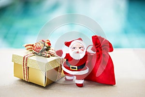 Christmas concept background of Santa Claus with gold gift box and red gift bag