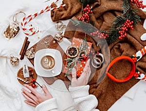 Christmas concept. Cozy winter atmosphere. Coffee cup, gift and decorations