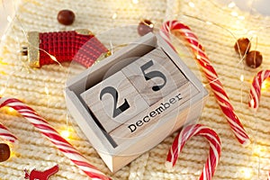 Christmas concept: December 25th wooden calendar blocks with Christmas decorations on white background, copy space for text. Woode