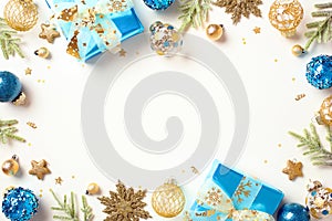 Christmas concept. Flat lay composition with blue and gold decorations, luxury gifts, confetti, fir branches isolated on white