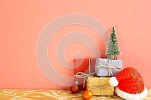 Christmas concept. Gift boxes with fir tree, baubles, santa claus hat on wooden table