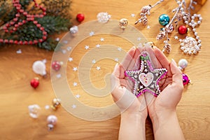 Christmas concept. Human hand hold a glass christmas bauble with festive lights