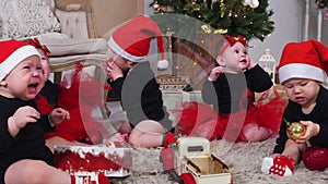 Christmas concept - Little babies sitting on the carpet and playing with christmas toys