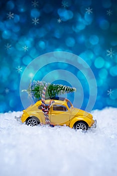 Christmas concept with miniature car toy carrying a Christmas tr