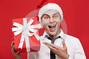 Christmas Concept - portrait close-up Santa christmas businessman over red background holding red gift.