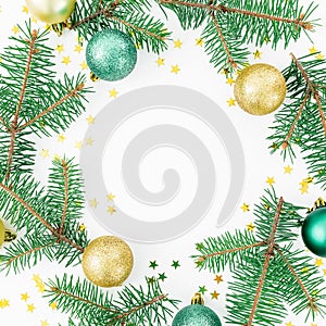 Christmas concept. Round frame of fir branches, glass balls and golden confetti on white background. Flat lay, top view